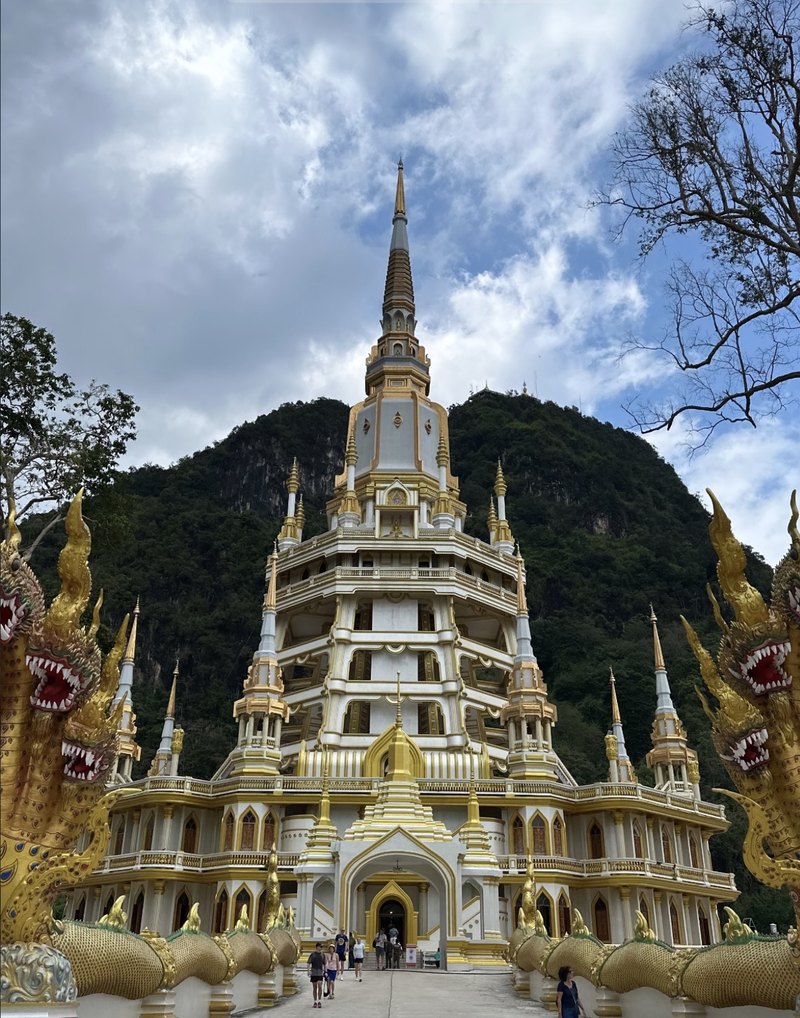 Templo branco e dourado diante da montanha, na Tailândia